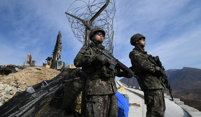 South Korean soldiers stand guard as construction equipment destroy a guard post in the Demilitarized Zone dividing the two Koreas in Cheorwon on November 15, 2018. (Reuters file photo)