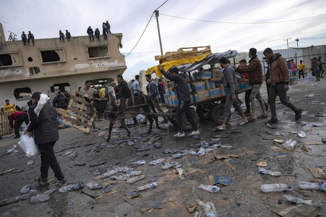 FILE — Palestinians loot a humanitarian aid truck as it crossed into the Gaza Strip in Rafah, Sunday, Dec. 17, 2023. A persistent breakdown in law and order is rendering an aid route in south Gaza unusable, the UN and NGOs say, days after Israel’s military said it would pause combat there to help aid reach desperate Palestinians. (AP)