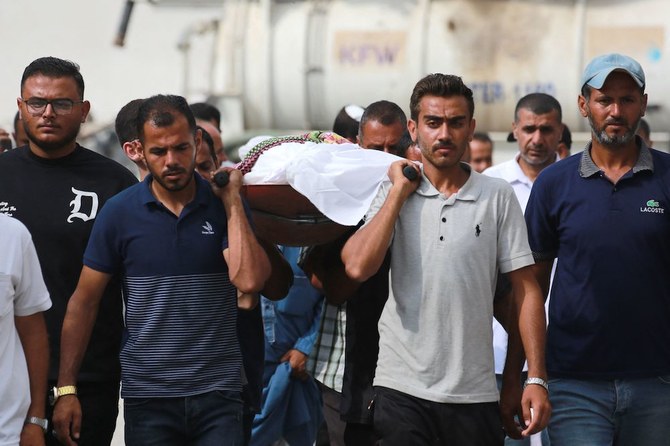 Above, Palestinian men carry a body for burial, killed the day before in a strike on the Al-Mawasi area of Rafah on June 22, 2024. (AFP)