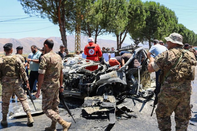 Above, emergency and security service members gather around the carcass of a car at the site of an Israeli strike in Al-Khiyara town in Lebanon’s Western Bekaa area on June 22, 2024. (AFP)