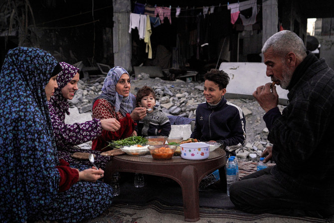 The Palestinian Al-Naji family eats an iftar meal, the breaking of fast, amidst the ruins of their family house.