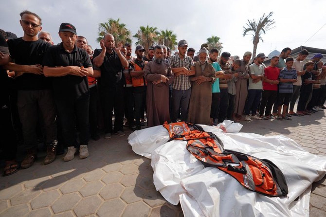 Above, mourners pray over the bodies of four civil defense volunteers killed during the Israeli bombardment of the Nuseirat refugee camp on June 28, 2024. (AFP)