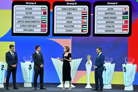 Japanese former footballer Shinji Okazaki (2nd L) and Iranian former footballer Mehdi Mahdavikia (R) stand on stage after the 2026 World Cup qualifying draw for Asian Football Confederation teams in Kuala Lumpur on June 27, 2024. (AFP)