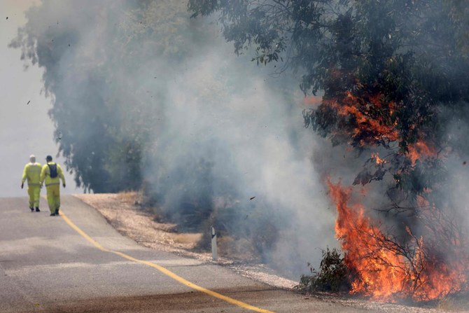 Israeli firefighters put out flames in a field after rockets launched from southern Lebanon landed on Banias area in the Israel-annexed Golan Heights amid ongoing cross-border clashes between Israeli troops and Hezbollah fighters. (File/AFP)