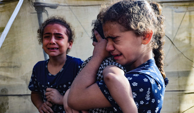 Children react during the funeral of the Faojo family, killed in Israeli bombing on Rafah in the southern Gaza Strip on November 11, 2023, as battles between Israel and the Palestinian Hamas movement continue. (AFP)