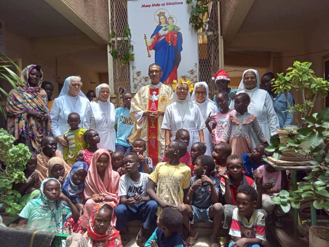 Priest Jacob, nuns and the refugees pose for a photos at “Dar Mariam” a Catholic church and school compound in Al-SHajjara district, where they took shelter, in Khartoum in this undated handout picture. (Reuters)