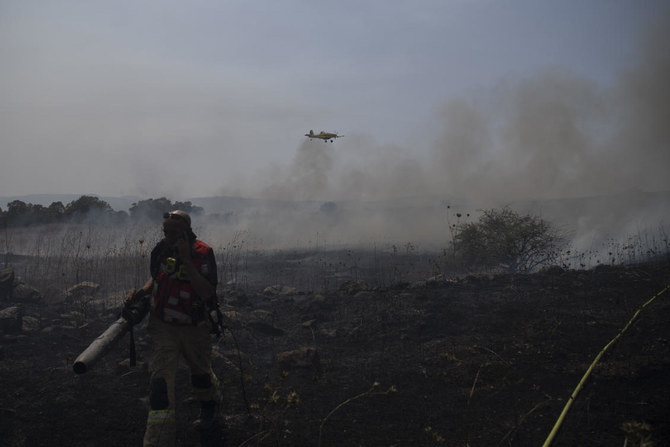 A firefighter works to extinguish a fire following an attack from Lebanese Hezbollah group in the Israeli-controlled Golan Heights. (AP)