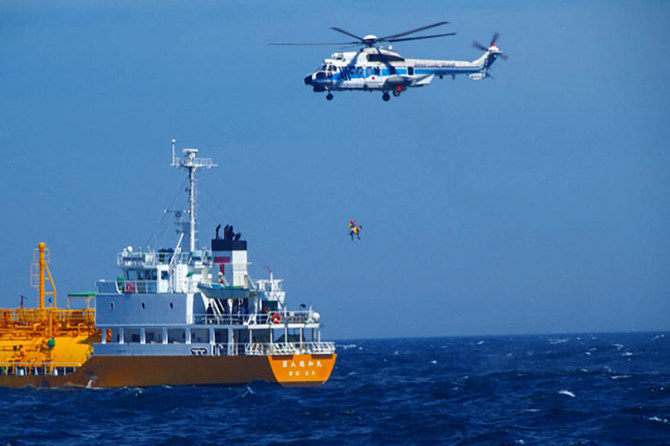 A coast guard helicopter lifts a woman, who had been swept out to sea off the southern tip of Chiba’s Boso peninsula, from a tanker where she had been receiving medical attention after being found. (Japan Coast Guard Yokosuka Office/AFP)