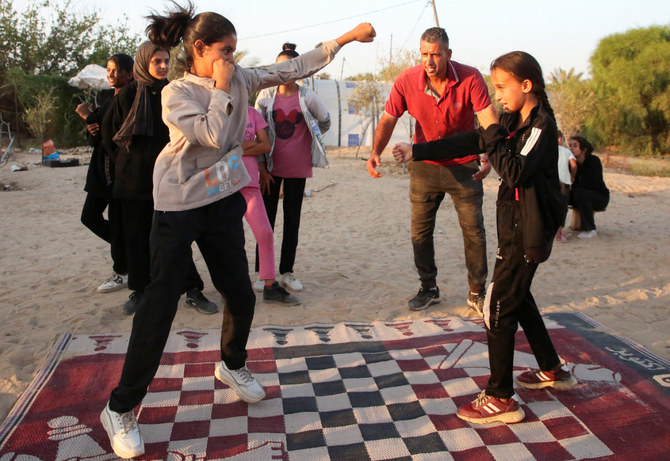 Palestinian boxing coach Osama Ayoub trains girls on boxing near a tent camp sheltering displaced people, amid Israel-Hamas conflict, in Khan Younis in the southern Gaza Strip July 10, 2024. (REUTERS)