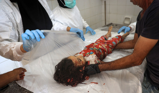 Medical personnel at the al-Aqsa Martyrs hospital prepare a young victim for burial after she was killed in an Israeli bombing in Deir el-Balah in the central Gaza Strip on July 13, 2024. (AFP)