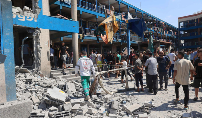Palestinians survey the damage following the Israeli military bombardment of the UNRWA (United Nations Relief and Works Agency for Palestine Refugees) run Abu Araban school, turned shelter, where internally displaced Palestinians are living, in the Nuseirat refugee camp, in the central Gaza Strip on July 14, 2024, amid the ongoing conflict between Israel and the Palestinian Hamas militant group. (AFP)