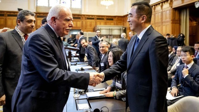 Palestinian FM Riyad Al-Maliki shakes hands with Ma Xinmin, China’s foreign ministry legal adviser, during a hearing at the International Court of Justice in The Hague, Feb. 22, 2024 (AFP)