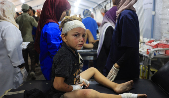 A wounded Palestinian child is treated at the al-Awda Hospital in Nuseirat refugee Camp after the Israeli military bombardment of the UNRWA (United Nations Relief and Works Agency for Palestine Refugees) run Abu Araban school, turned shelter, where internally displaced Palestinians are living, in the Nuseirat camp, in the central Gaza Strip on July 14, 2024, amid the ongoing conflict between Israel and the Palestinian Hamas militant group. (AFP)