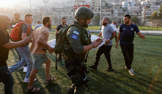 Israeli security forces and medics transport casualties from a site where a reported strike from Lebanon fell in Majdal Shams village in the Israeli-annexed Golan area on July 27, 2024. (AFP)