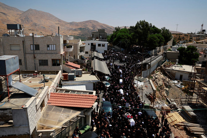Mourners carry coffins, during the funeral of children who were killed at a soccer pitch by a rocket fired from Lebanon, in Majdal Shams, a Druze village in the Israeli-occupied Golan Heights, July 28, 2024. (Reuters)