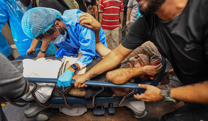 A photo taken on July 30, 2024, shows medical staff carrying on an injured man on a stretcher at the Bahman hospital following an Israeli military strike on a building in Beirut's southern suburb. (AFP)