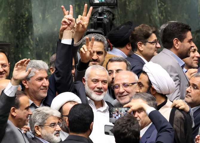 Ismael Haniyeh, Palestinian leader of the militant group Hamas, surrounded by lawmakers flashes the victory sign during the swearing in ceremony for the new Iranian President, at the parliament in Tehran on July 30, 2024. Iranian reformist Masoud Pezeshkian was sworn as the Islamic republic's ninth president. (Photo by AFP)