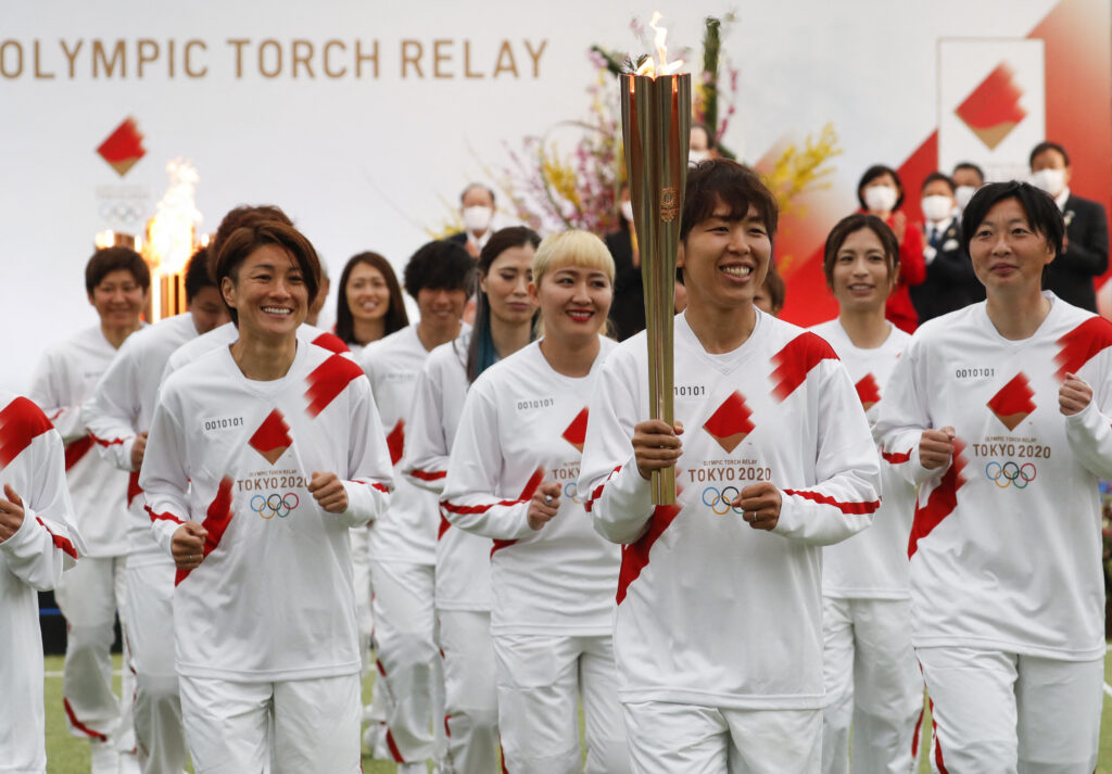 Tokyo 2020 Olympic Torch Relay Grand Start torchbearers from Japan's women's national football team, or Nadeshiko Japan, lead the torch relay in Naraha, Fukushima prefecture on March 25, 2021. (AFP)