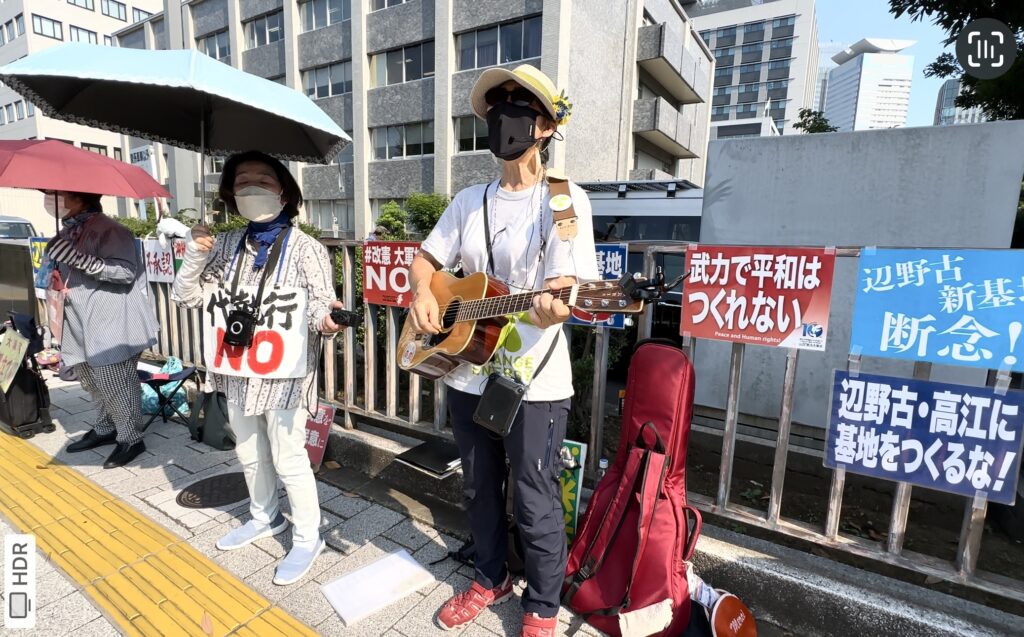 Protesters against American bases in Okinawa perform at the sidewalk facing the Prime Minister Building in Tokyo on Friday. (ANJ)