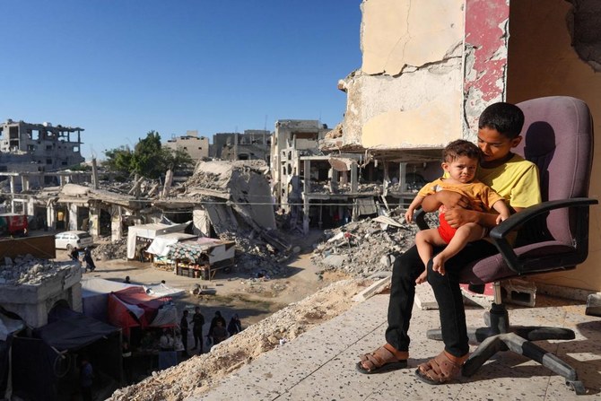Palestinian children sit on the balcony of their house which was heavily damaged by Israeli bombardment, in the town of Bani Suheila near Khan Yunis, southern Gaza Strip on July 17, 2024. (AFP)