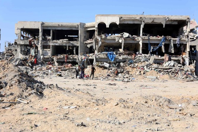 Palestinians stand in front of destroyed buildings and rubble after the Israeli military withdrew from the Shujaiya neighborhood, east of Gaza City on Jul. 10, 2024. (AFP)