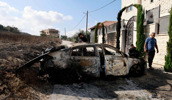 People check a burnt car a day after an attack by Jewish settlers on the village of Jit near Nablus in the occupied West Bank that left a 23-year-old man dead and others with critical gunshot wounds, on August 16, 2024. (AFP)
