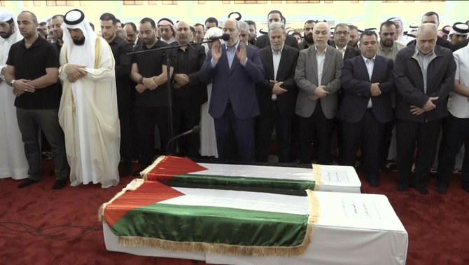 This video grab shows senior Hamas official Khalil al-Hayya, center, praying near the coffin of Hamas leader Ismail Haniyeh and his bodyguard during the funeral prayers in Doha, Qatar, Friday Aug. 2, 2024. (Qatar TV via AP)