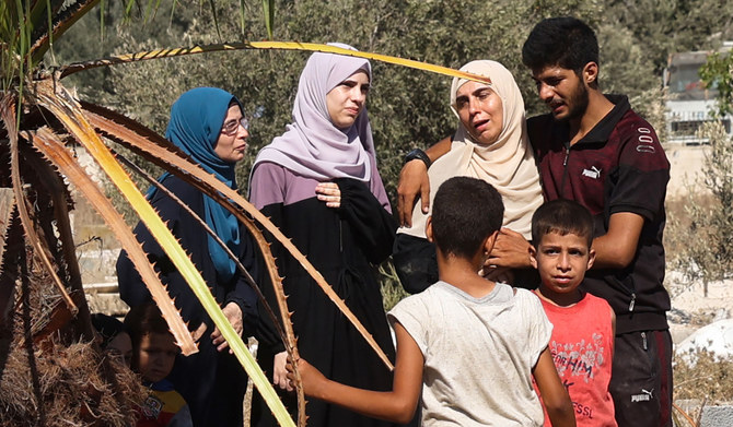 Distressed Palestinian family members are comforted during a funeral at the Al-Zawaida Cemetery in the central Gaza Strip. (AFP)
