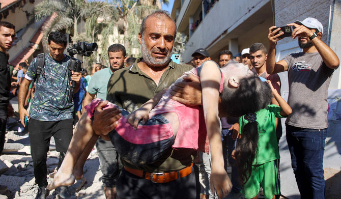A man carries the body of a girl killed during Israeli bombardment on the Al-Nassr school that houses displaced Palestinians, West of Gaza city, on August 4, 2024, amid the ongoing conflict between Israel and the militant Hamas group. (AFP)