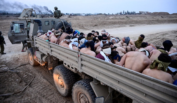 Israeli soldiers stand by a truck packed with shirtless Palestinian detainees, amid the ongoing conflict between Israel and the Palestinian Islamist group Hamas, in the Gaza Strip December 8, 2023. (REUTERS)