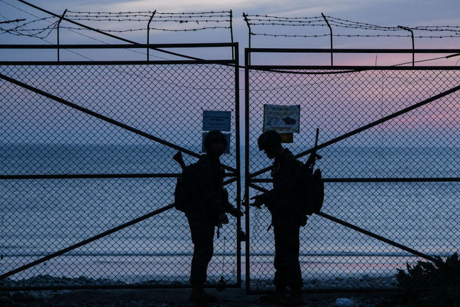 Above, South Korean soldiers stand at a security fence on the island of Yeonpyeong near the disputed waters of the Yellow Sea. (AFP file photo)
