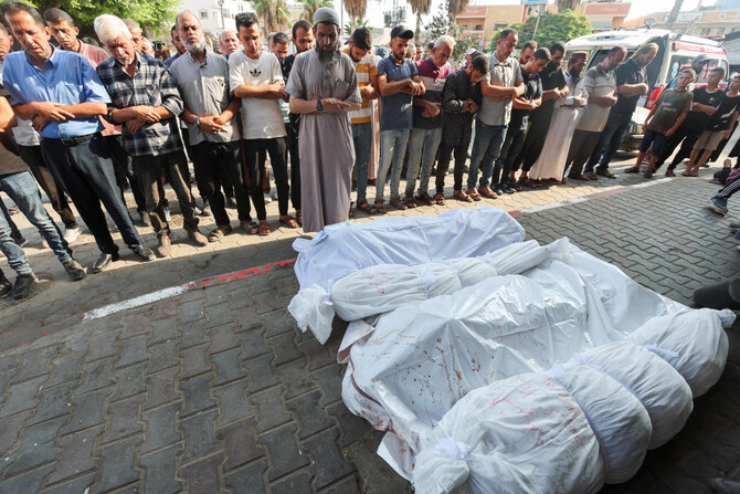 Mourners pray next to the bodies of Palestinians killed in Israeli strikes at Al-Aqsa Martyrs Hospital in Deir Al-Balah in the central Gaza Strip, on Aug. 14, 2024. (Reuters)