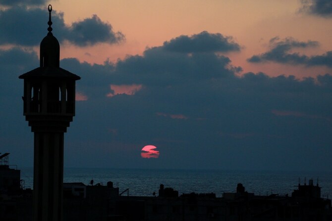 The minaret of a mosque is silhouetted in Deir al-Balah in the central Gaza. (AFP)