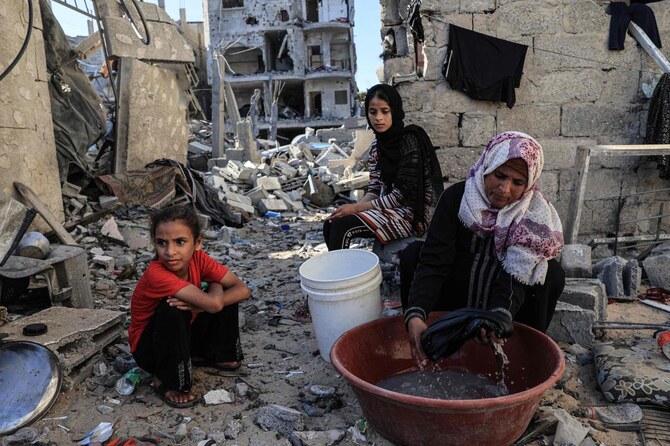 Palestinian women wash their clothes using sea water due to the lack of fresh water and electricity, along the beach in Deir el-Balah in the southern Gaza Strip on October 29, 2023, amid the ongoing battles between Israel and the Palestinian group Hamas. (AFP)