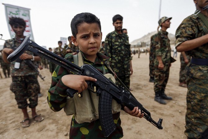 A Yemeni boy poses with a Kalashnikov assault rifle during a gathering of newly-recruited Houthi militants in the capital Sanaa. (AFP)