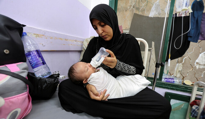 A Palestinian woman bottle-feeds her baby girl at Al-Aqsa Martyrs Hospital, amid fears over the spread of polio after the first case was reported by the Ministry of Health, as the conflict between Israel and Hamas continues, in Deir Al-Balah in the central Gaza Strip, August 18, 2024. (REUTERS)