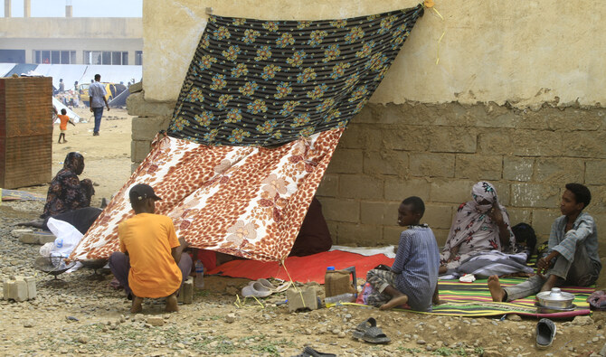 Sudanese already displaced by conflict, rest under a blanket at a makeshift campsite they were evacuated to following deadly floods in the eastern city of Kassala on August 12, 2024. (AFP)