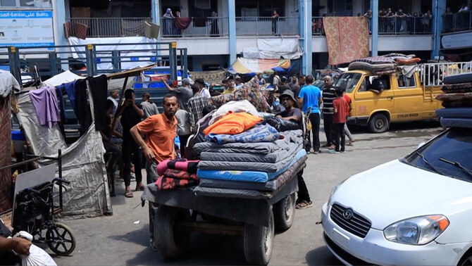 Palestinians load their carts and vehicles with belongings as they evacuate Deir al-Balah Boys' Preparatory School following an evacuation order by the Israeli army on August 16, 2024. (Screen grab from OCHA handout video via REUTERS)