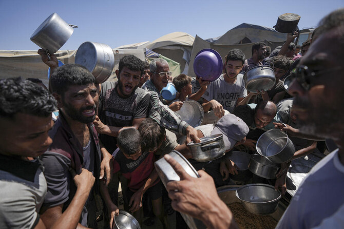 Displaced Palestinians gather at a food distribution center in Deir al Balah, central Gaza Strip. (AP)