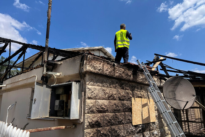 A worker stands atop a damaged residential building after Hezbollah fired a barrage of projectiles towards in Kiryat Shmona in northern Israel on August 24, 2024. (REUTERS)