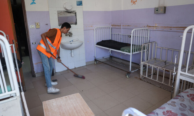 A member of staff cleans an empty ward of the Al-Aqsa Martyrs Hospital in Deir Al-Balah in the central Gaza Strip following renewed Israeli evacuation orders for the area on August 26, 2024, amid the ongoing conflict between Israel and the Palestinian Hamas movement. (AFP)