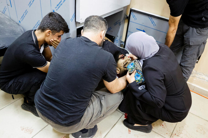 People mourn next to the body of a Palestinian killed in an Israeli air strike on a car, at a morgue in Tubas, in the Israeli-occupied West Bank, August 28, 2024. (REUTERS)