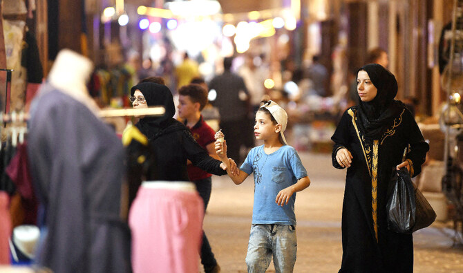 People walk along an alley during the reopening of restored historic bazaars that were damaged during the Syrian conflict in Aleppo. (AFP)