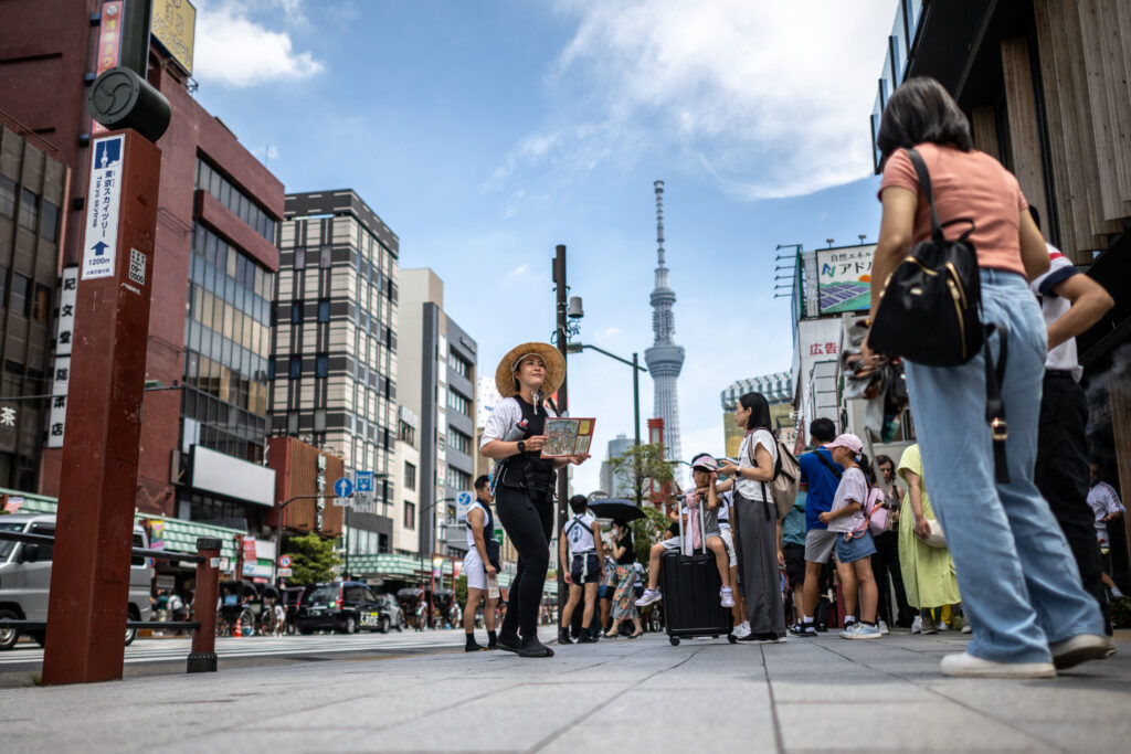 A rickshaw driver (C) works outside Sensoji Temple at the Asakusa district of Tokyo on July 31, 2024. (AFP)
