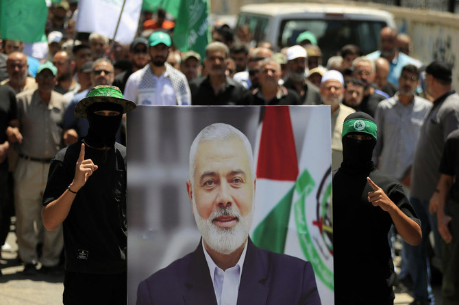 Hamas members hold a poster of Hamas political chief Ismail Haniyeh during a protest to condemn his killing, at Al-Bass Palestinian refugee camp, in the southern port city of Tyre, Lebanon, on Jul. 31, 2024. (AP)