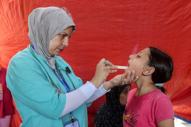 Lobna Al-Azaiza, a Palestinian pediatrician providing free medical services to displaced Palestinians, examines a girl in a tent near her house, which was destroyed in an Israeli strike in Deir Al-Balah on Aug. 12, 2024. (Reuters)