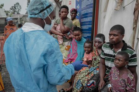 Patients listen to a doctor outside the consultation room of the Mpox treatment centre at Nyiragongo General Referral Hospital, north of Goma on August 17, 2024. (AFP)