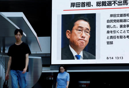 People walk past a large screen in Tokyo showing the news about Japanese Prime Minister KISHIDA Fumio's announcing his resignation. (Reuters)