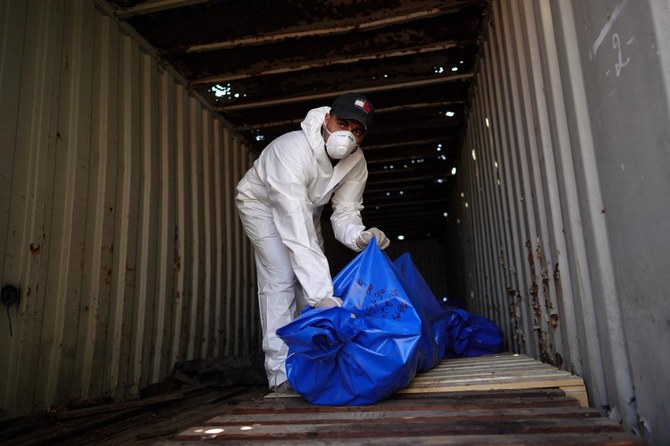 A man removes bodies from a container after they were taken and later released by Israel, ahead of a mass funeral at a cemetery in Khan Yunis in the southern Gaza Strip on August 5, 2024. (AFP)