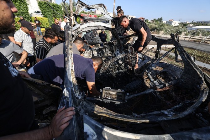 People check a car reportedly hit by an Israeli strike in the village of Zeita near Tulkarem in the occupied West Bank on August 3, 2024. (AFP)